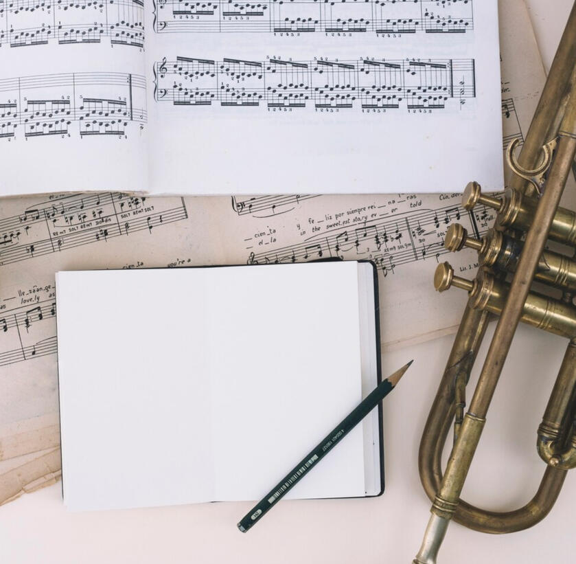 A picture of an empty notebook surrounded by musical score sheets. A metaphor to a student learning new music theory concepts. A picture of an empty notebook surrounded by musical score sheets. A metaphor to a student learning new music theory concepts.